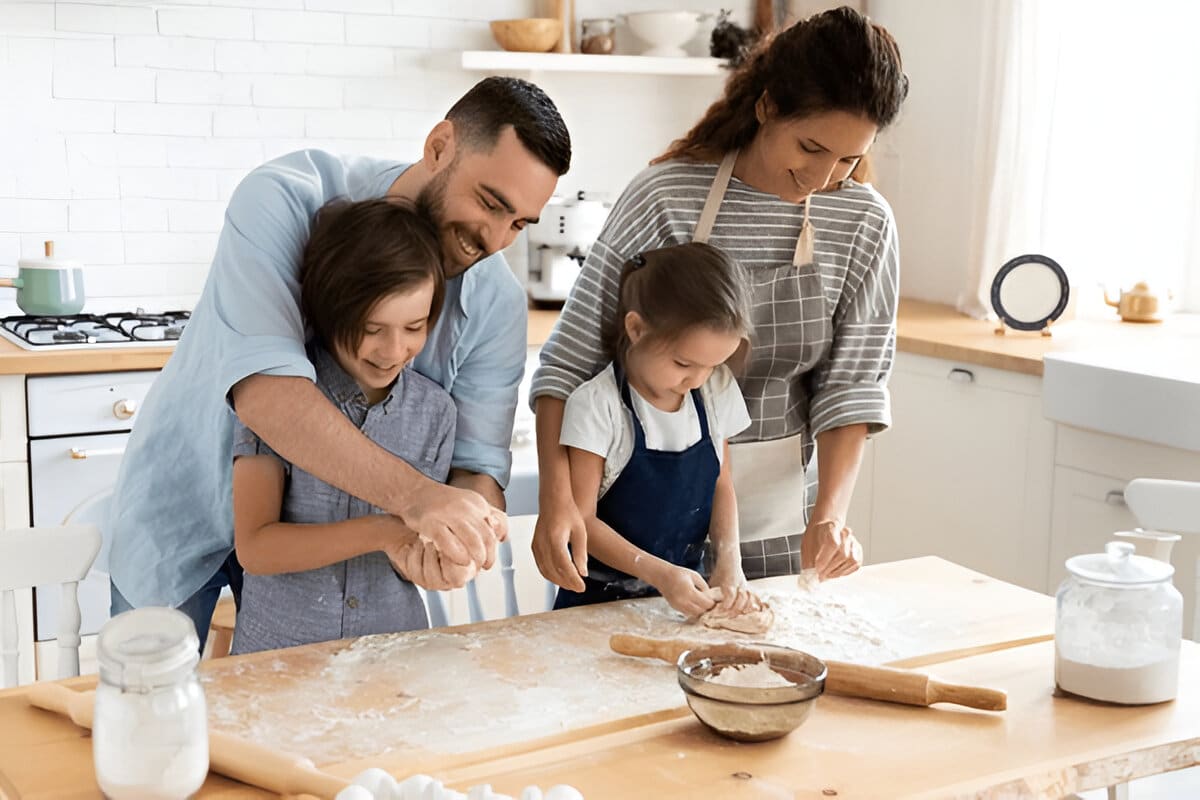 ivy-elena-family-cooking-together Family fun in the kitchen — Ivy, her husband, and their two kids making memories while baking together